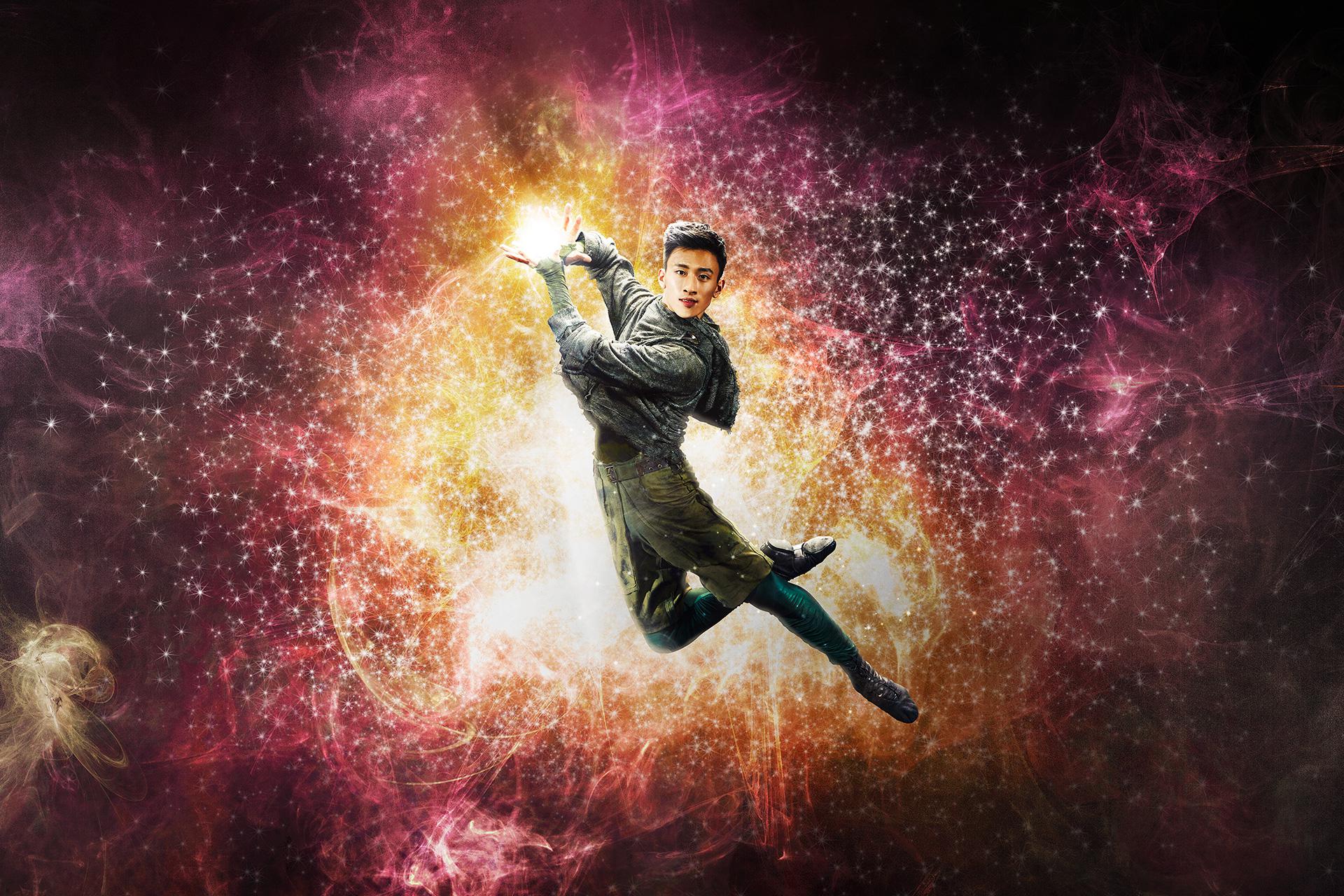 Dancer leaps holding light in his hands.