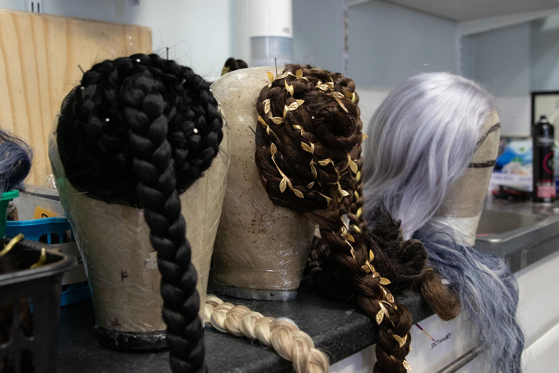 A black and a brown pair of hair extensions, and a lilac coloured wig.