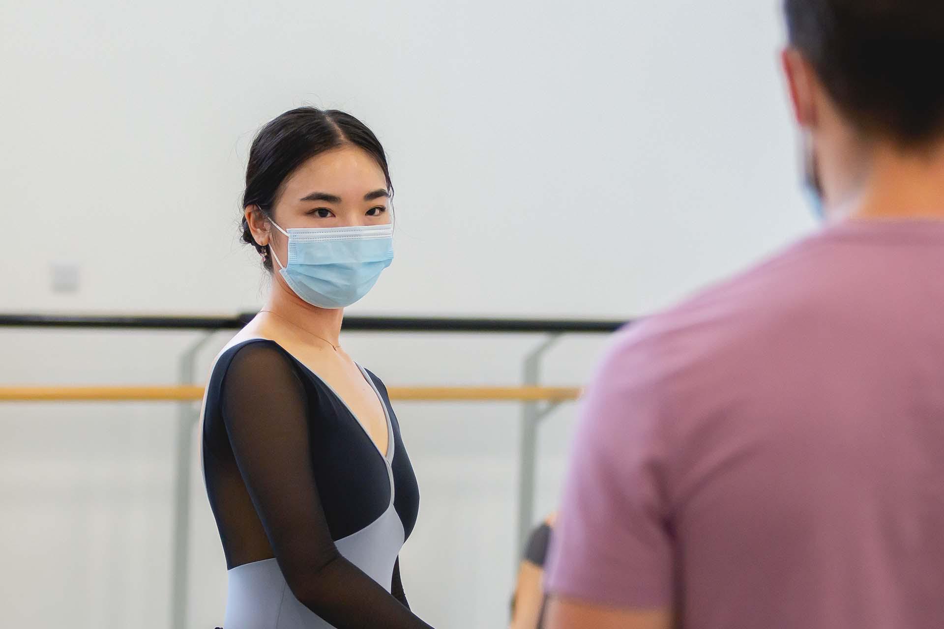 A dancer taken instruction and notes from the choreographer