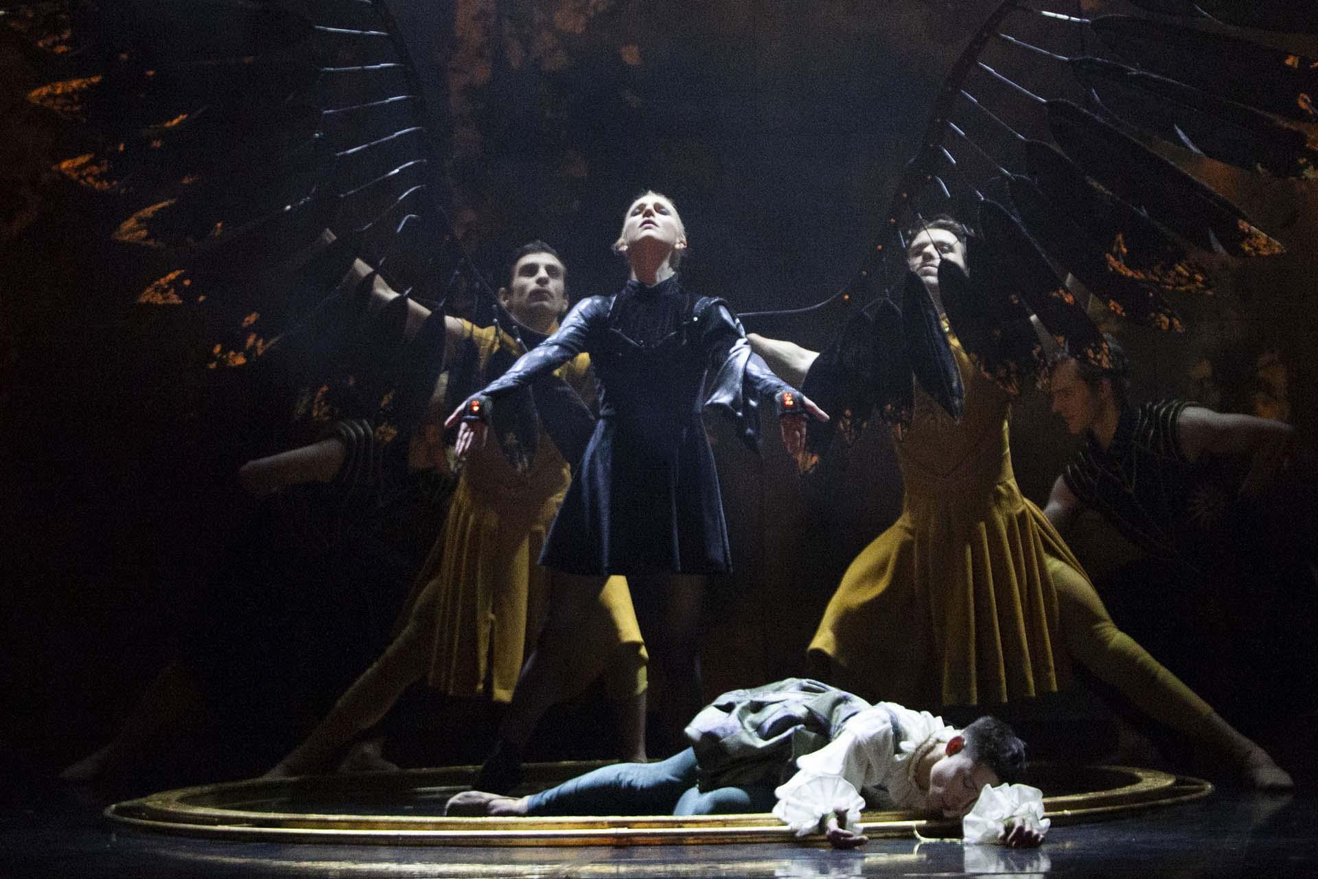 Morgan stands proudly with her new black wings unfurled while Merlin lies drained at her feet