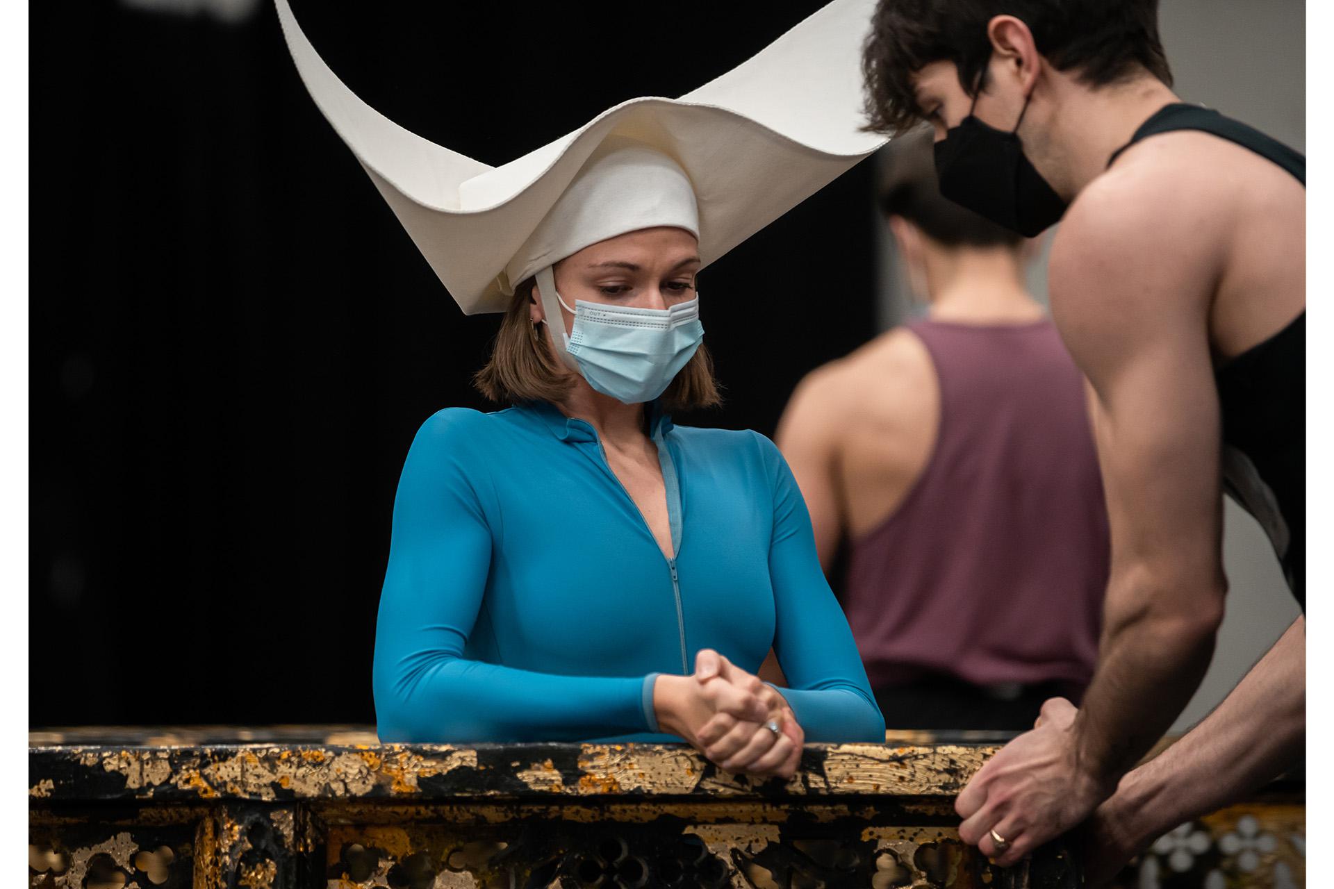 A dancer wearing an exaggerated wimple acting as a nun in prayer