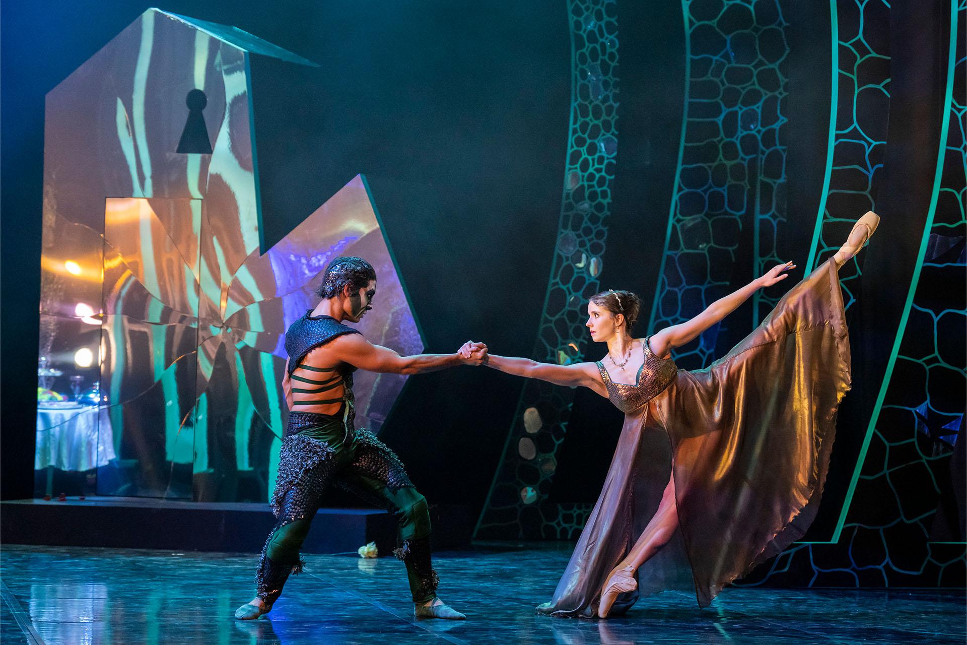 The Beast and Beauty facing each other but pulling away while holding a hand.