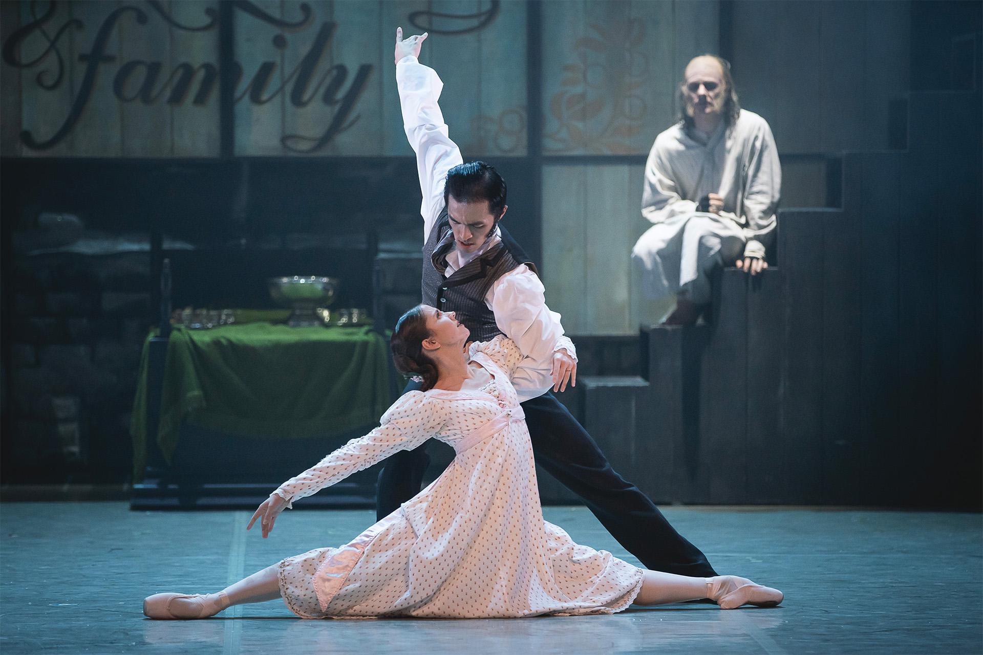 Scrooge watches on from a step in the background as a Young Scrooge dancers with Belle in the foreground.