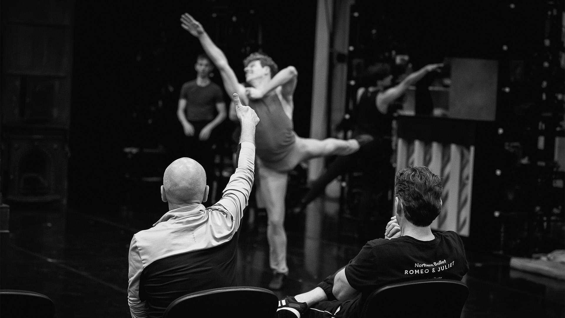 A dancer in the background while a rehearsal director has a thumbs up