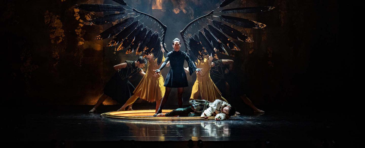 Morgan extend her wings with the power she has stolen from Merlin, lying prone at her feet