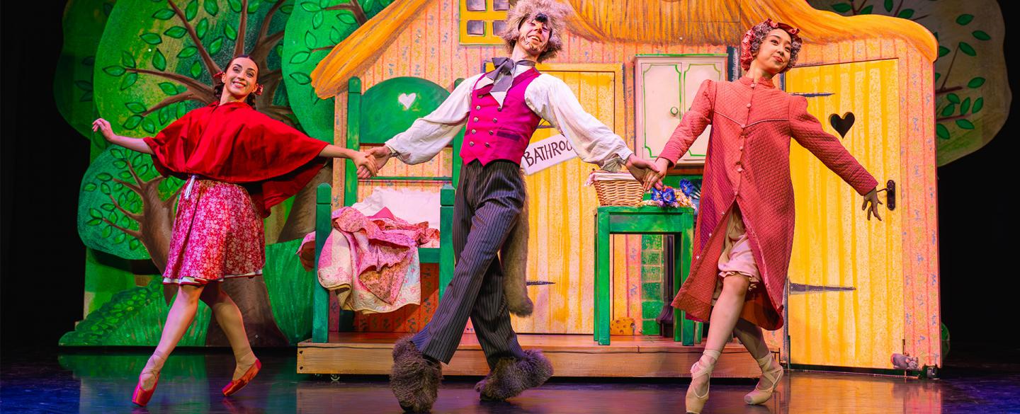 Little Red, her grand-mother and the wolf all dance together, happily and hand-in-hand