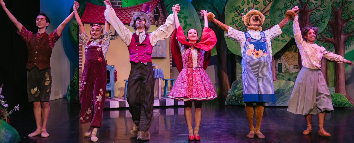 Six dancers in costume of Little Red Riding Hood taking a bow