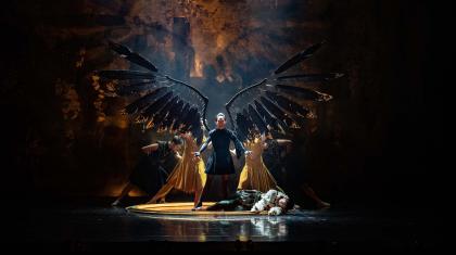 Morgan extend her wings with the power she has stolen from Merlin, lying prone at her feet