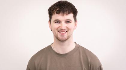 Man in khaki t-shirt, short brown hair, smiling open-mouthed