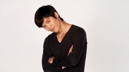 Yosuke Mino publicity photo of him wearing a black top and his arms folded