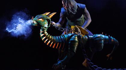 The dragon, small and still developing, fire lighting his throat and smoke coming from its nostrils