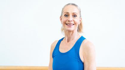 Smiling woman with tied back hair and wearing a blue vest